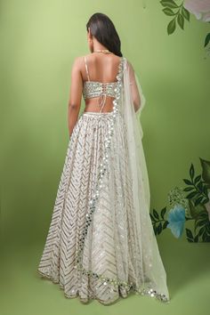 Ivory,off white georgette lehenga with attached cancan and chevron embroidery in sequins, mirror and patra. Comes with embellished padded blouse and floral bordered dupatta.
Component: 3
Pattern: Embroidery
Type Of Work: Sequins, Mirror, Patra
Neckline: V Neck
Sleeve Type: Sleeveless
Fabric: Lehenga and Blouse: Georgette, Dupatta: Net
Color: Ivory
Other Details: 
Attached lining
Sequins, mirror and patra work
Note: The neckpiece worn by the model is not for sale
Occasion: Bride,Wedding - Aza Fas White Georgette Lehenga, Chevron Embroidery, Ivory Lehenga, Sequins Lehenga, Lehenga And Blouse, Georgette Lehenga, Georgette Dupatta, Padded Blouse, Pattern Embroidery