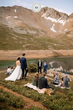 a group of people standing around a lake