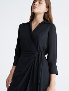 Elevated elegance accentuated by sculptural form. Designed with a wrap-tie detail, this dress features a gentle drape along the leg. Made with long sleeves and a point collar for a refined touch.  Material: 100% Polyester. Elegant V-neck Shirt Dress For Evening, Elegant Asymmetrical Midi Dress For Work, Elegant Asymmetrical Semi-formal Dress, Formal Long Sleeve Wrap Dress For Spring, Long Sleeve Wrap Dress For Spring Formal, Chic Long Sleeve Wrap Dress For Evening, Elegant Asymmetrical Workwear Dresses, Evening Pre-draped Long Sleeve Midi Dress, Asymmetrical Wrap Dress For Spring Formal