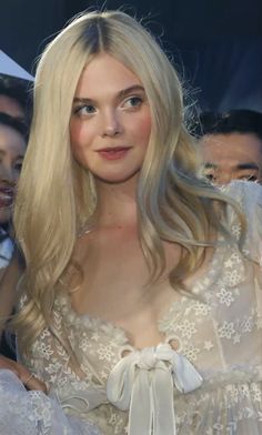 a woman with long blonde hair wearing a white dress