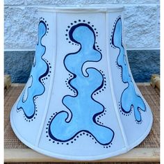 a blue and white lamp shade sitting on top of a table