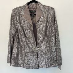 This Is A Brand New With Tags Dress Jacket By Cachet. Retail Tag Of $219 Reads Metallic, Animal Print. Jacket Is Light Very Well Tailored And Structured, A Knit Fabric In Gray With Silver Print It Creates A Very Smooth Silhouette While Being Light And Easy To Wear. Collar Is A Gray Satin. Colors Are Accurate In Photos And Excellent Piece To Wear Over Any Gown Or Dress. Or, Where With A Crisp, White Blouse And Jeans For Fall. All Labels Intact, First Quality. Size Reads 16w, But Please Read Measu Elegant Metallic Long Sleeve Blazer, Fitted Silver Blazer For Evening, Elegant Fitted Metallic Outerwear, Elegant Festive Outerwear For Celebrations, Elegant Festive Outerwear For Party Season, Elegant Holiday Festive Blazer, Elegant Silver Blazer For Evening, Elegant Silver Evening Blazer, Elegant Metallic Outerwear For Parties