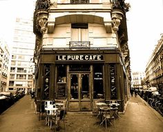 an old building with tables and chairs in front of it on the side of a street