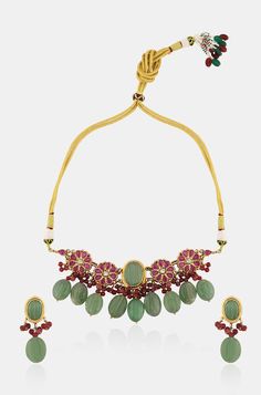 Elevate your outfit with our elegant necklace set, featuring a stunning centerpiece adorned with a beautiful green jade stone. Surrounding the centerpiece is a floral pattern embellished with red garnet stones, accented with red onyx and green jade stones, adding a touch of elegance and sophistication. Complete your look with the matching earrings for a coordinated and stylish ensemble. Finish: 22KT Gold Plating Material: Silver, Copper Alloy, Semi Precious Stones Color: Green Size: Free Size, A Traditional Green Ruby Jewelry, Green Ruby Necklace For Celebrations, Traditional Green Gemstone Jewelry Sets, Green Emerald Jewelry For Gift, Green Emerald Gemstone Necklace For Festivals, Green Emerald Necklace For Festivals, Green Emerald Necklace With Gemstone For Festivals, Green Gemstone Temple Jewelry Sets, Festive Green Gemstone Jewelry Sets