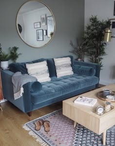 a living room filled with furniture and a round mirror