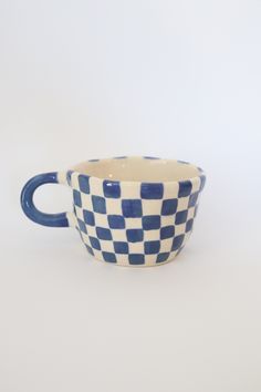 a blue and white checkered cup sitting on top of a table