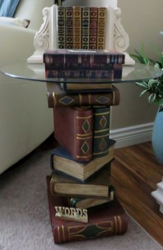 a stack of books sitting on top of a glass table