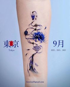 a woman's leg with blue flowers and feathers on the side of her body