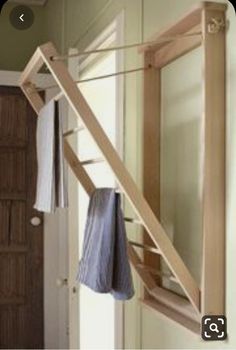 a towel rack hanging on the wall next to a door with a mirror above it