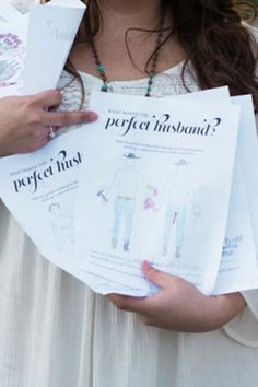 a woman is holding several papers in her hands