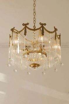 a chandelier hanging from the ceiling in a room with white walls and flooring