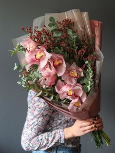 a woman holding a bouquet of pink flowers