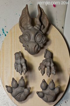 some clay animals are on a wooden plate