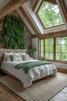 a large bed sitting under a window next to a green plant on top of a wall