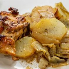 a white plate topped with chicken, potatoes and artichokes on top of it