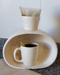 there is a coffee cup and saucer in the shape of a vase on top of a counter