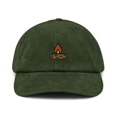 a green hat with a campfire embroidered on the front, and an orange flame in the center