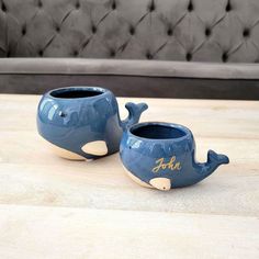 two blue whale planters sitting on top of a wooden table