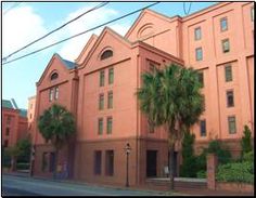 an orange building with palm trees in front of it on the corner of a street