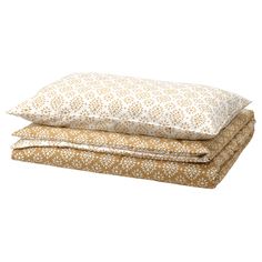 two pillows stacked on top of each other in front of a white background with brown and tan flowers