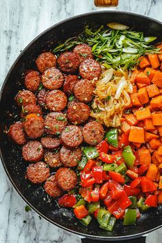 meatballs and vegetables cooking in a skillet