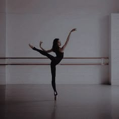 a ballerina in a ballet studio with her arms stretched out and one leg bent forward