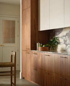 a kitchen with wooden cabinets and marble counter tops, along with a dining room table