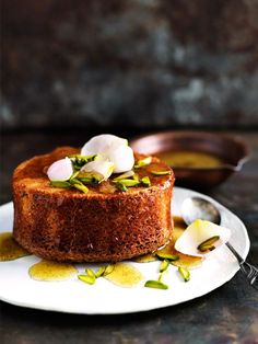 a cake on a plate with flowers and sauce