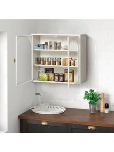 an open cabinet above a sink in a room with white tiles on the wall and wooden counter top