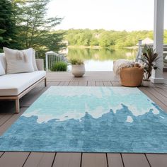 a blue and white rug sitting on top of a wooden floor next to a couch