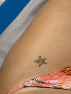 a small starfish tattoo on the back of a woman's thigh