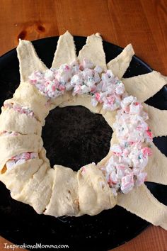 a bundt cake with white frosting and sprinkles sitting on a black plate