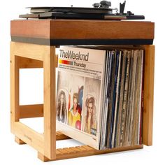 an old record player is sitting on top of a wooden stand with records in it