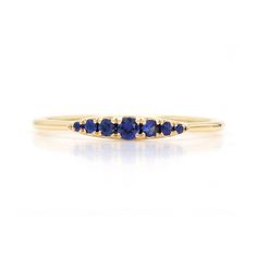 This glittering delicate seven-stone ring showcases beautiful round-cut gemstones of your choice mounted in a graduated design. Crafted in solid 18k gold. Detailed Description: * Metal: 18K Yellow Gold * Stones: Genuine Blue Sapphires * Count: 7 PCS * Weight: 0.13cts T.W * Face measures: 10mm * Band Measures: 1mm Stone Measurements: * 2 mm x 1 * 1.6 mm x 2 * 1.3 mm x 2 * 0.9 mm x 2 Also available in the following gemstones: * Ruby * Vivid Pink Sapphires * Light Pink Sapphires * Yellow Sapphires Yellow Gold Stackable Rings With Sapphire In Round Band, Sapphire Gemstone Stackable Rings With Round Band, Sapphire Gemstone Stackable Rings, Classic Stackable Sapphire Rings In Yellow Gold, Yellow Gold Sapphire Stackable Rings With Round Cut, Classic Sapphire Gemstone Stackable Rings, Sapphire Stackable Round Band Rings, Classic Sapphire Stackable Rings With Gemstones, Sapphire Birthstone Ring Fine Jewelry