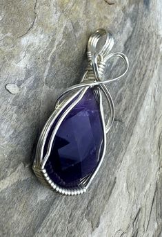 Heidi White Designs Wire Wrapped Pendant Amethyst and Sterling Silver1&1/2 X 3/4 inchThis is a ready to wear or use in one of your own designs wire wrapped pendant. This pendant is wrapped in sterling silver wire and features a natural faceted Amethyst Cabochon. Purple Wire-wrapped Silver Jewelry, Purple Sterling Silver Wire Wrapped Jewelry, Purple Wire Wrapped Pendant Jewelry, Wire Wrapped Teardrop Amethyst Jewelry, Wire Wrapped Amethyst Pendant Jewelry, Wire Wrapped Amethyst Pendant, Faceted Gemstone Jewelry, Small Pendant, Wrapped Pendant