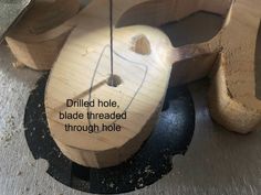 a piece of wood that has been carved to look like a boat with the words drilling hole, blade threaded through hole