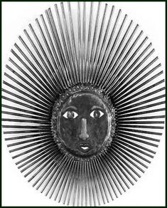 a black and white photo of a sun face with spikes on it's sides