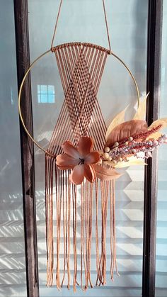 a dream catcher with feathers and flowers hanging from it's side