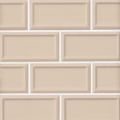 a white brick wall that is made up of several different sized tiles, all in shades of pink