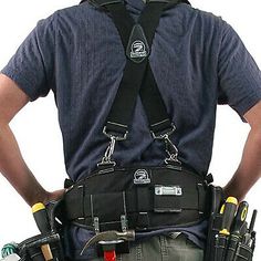 a man in overalls with tools on his back and hands behind his back as he stands