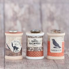 three spools of thread sitting next to each other on a wooden table top