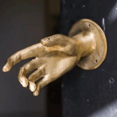 a gold hand that is on the side of a door