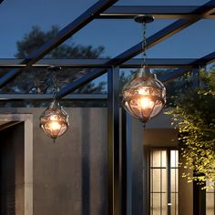 two lights hanging from the ceiling in front of a house