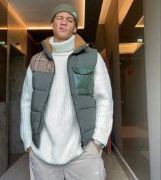 a man standing in an elevator with his hands in his pockets and looking at the camera