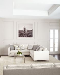 a living room filled with furniture and decor on top of a white carpeted floor