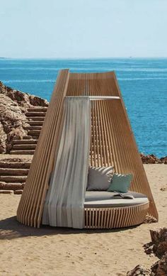 an outdoor lounge chair sitting on the beach