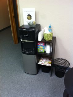 there is a small refrigerator next to a shelf with items on it in the corner