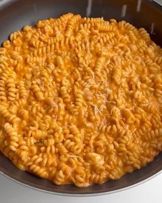 a pan filled with macaroni and cheese on top of a stove