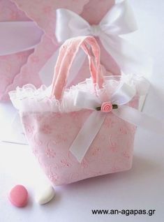 a small pink bag sitting on top of a white table next to some candies