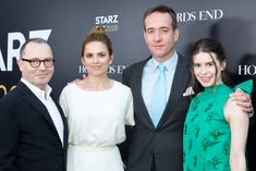 three people standing next to each other on a red carpet